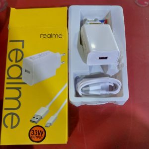 Realme 33W SuperDart Fast Charger Adapter | DeshiBD.com Power up your smartphone in minutes with the Original Realme 33W SuperDart Fast Charger, now available at DeshiBD.com. Designed for blazing-fast and safe charging, this genuine Realme power adapter delivers consistent performance and long-lasting reliability — perfect for all Realme smartphones and VOOC-compatible devices. ⚡ Key Features: ⚙️ 33W SuperDart Fast Charging: Boost your battery from 0% to 100% in record time. 🔋 Wide Compatibility: Works seamlessly with all Realme smartphones and VOOC-enabled devices. 🔒 Multiple Safety Protections: Built-in safeguards against overheating, overvoltage, and short circuits. 🧳 Compact & Portable Design: Lightweight and travel-friendly, perfect for everyday use. 🔌 EU/US Plug Options: Suitable for multiple regions and devices. 🎨 Elegant White Finish: Sleek, premium look that complements your device. 🔋 Product Description: Experience next-level charging with the Realme 33W SuperDart Fast Charger Adapter (Model: VCB3HDEH). Engineered with SuperDart and VOOC fast charging technology, this original Realme adapter ensures rapid and efficient power delivery for your smartphone. With a maximum output of 33W, it delivers high-speed charging while maintaining low temperature and stable current flow. The charger’s intelligent protection system shields your device from electrical hazards, providing a safe and reliable charging experience every time. Its compact, lightweight design makes it perfect for travel, while the durable build quality ensures long-term use. Compatible with a wide range of Realme smartphones, this adapter is ideal for users who need fast, dependable power wherever they go. ⚙️ Technical Specifications: Feature Details Brand Realme Model VCB3HDEH Color White Charging Technology SuperDart / VOOC Fast Charging Input 100–240V~50/60Hz 1.2A Output 5V=2A / 5V–11V~3A Maximum Output Power 33W Plug Type EU/US Compatibility All Realme Smartphones Warranty 3 Months 💡 Why Buy from DeshiBD.com: ✅ 100% Original Realme product ✅ Fast & safe charging with SuperDart technology ✅ Compact design for easy portability ✅ Backed by 3-month official warranty ✅ Best price in Bangladesh 💰 Realme 33W SuperDart Charger Price in Bangladesh: Get the Realme 33W SuperDart Fast Charger Adapter at the best price in Bangladesh from DeshiBD.com. Enjoy genuine quality, ultra-fast charging, and peace of mind with every purchase. ⚡ Charge Faster. Stay Powered. Go Real — only at DeshiBD.com!